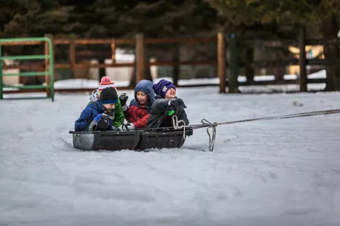 Schlittenfahrende Kinder im Schnee